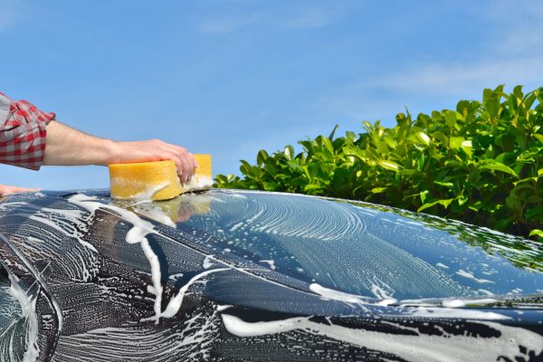 39494198 - car care man washing a car by hand using a sponge